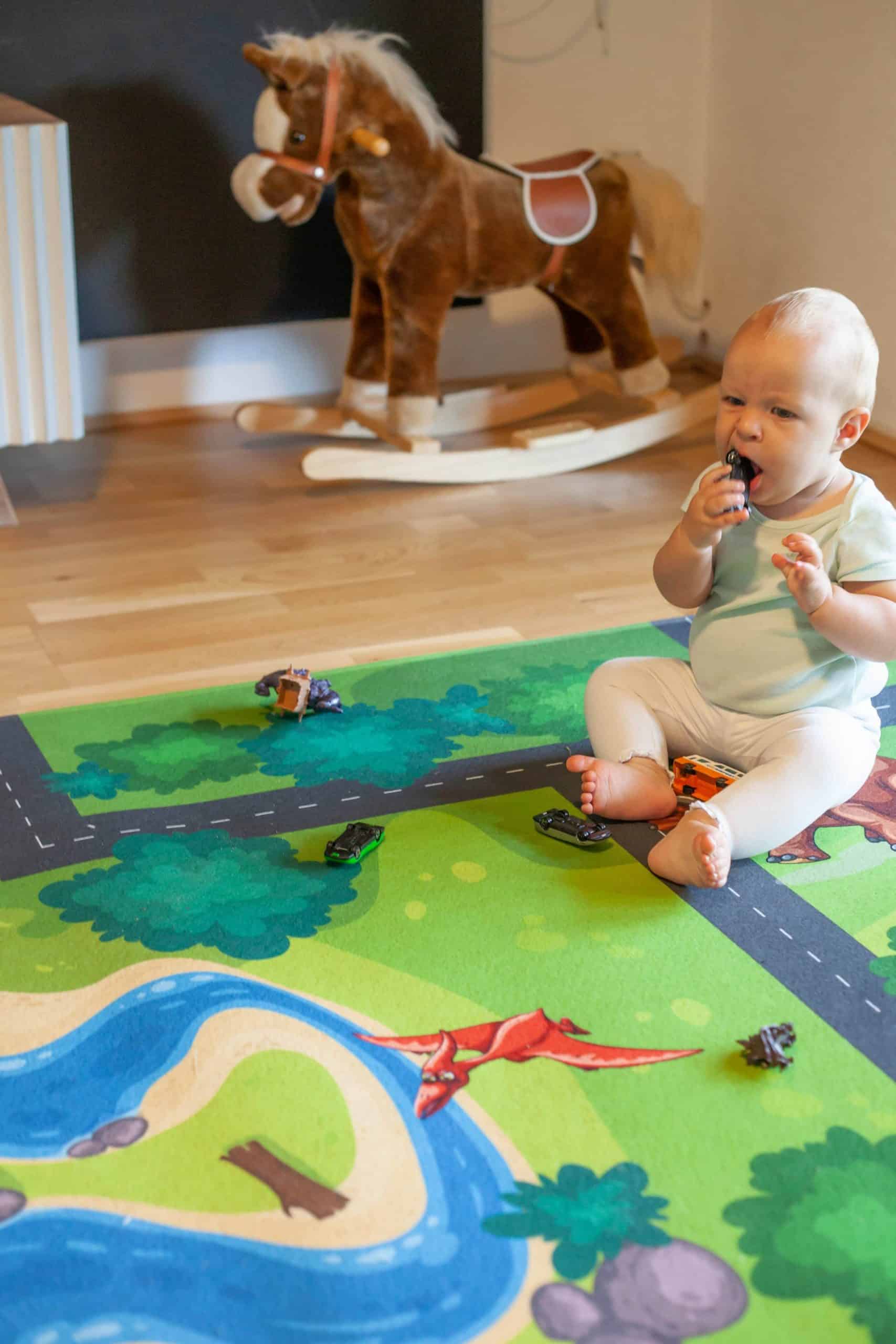 Säugling spielt auf Spielteppich Straße im Kinderzimmer