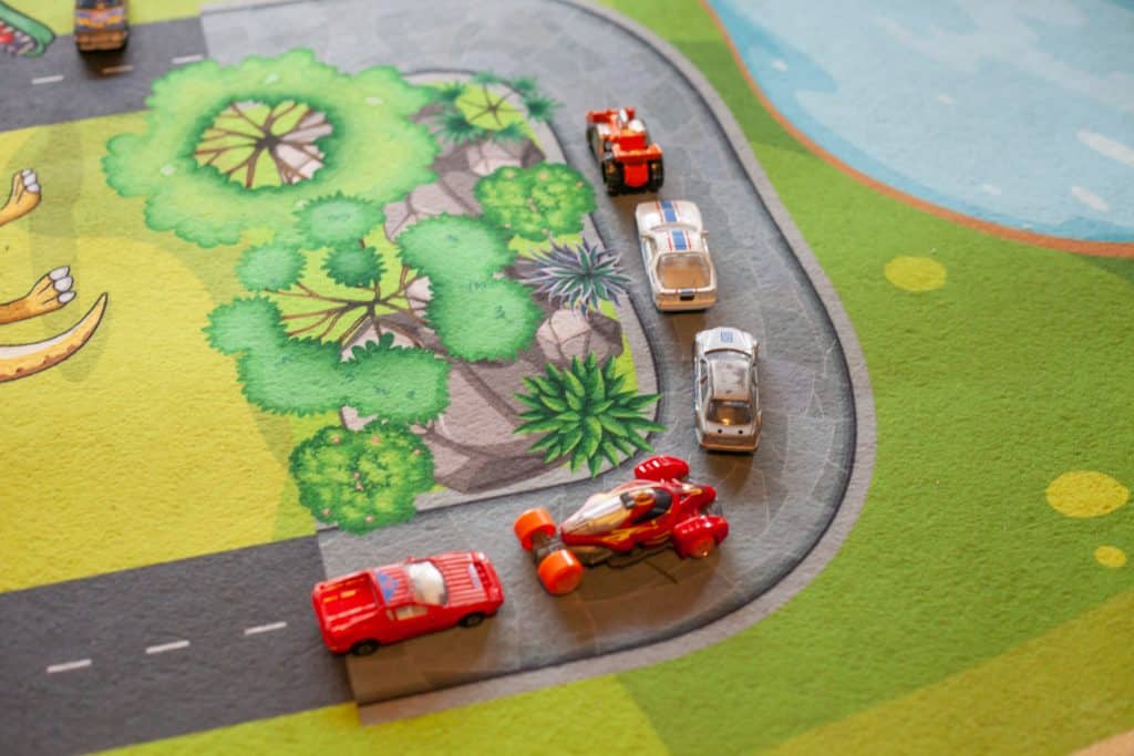 Spielzeug-Autos auf Spielteppich Straße